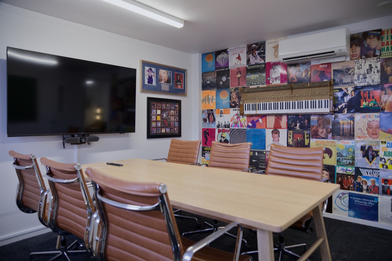 The Music Room: A wall of record covers, a long table and a screen. Good for workshops, interviews and team sessions.