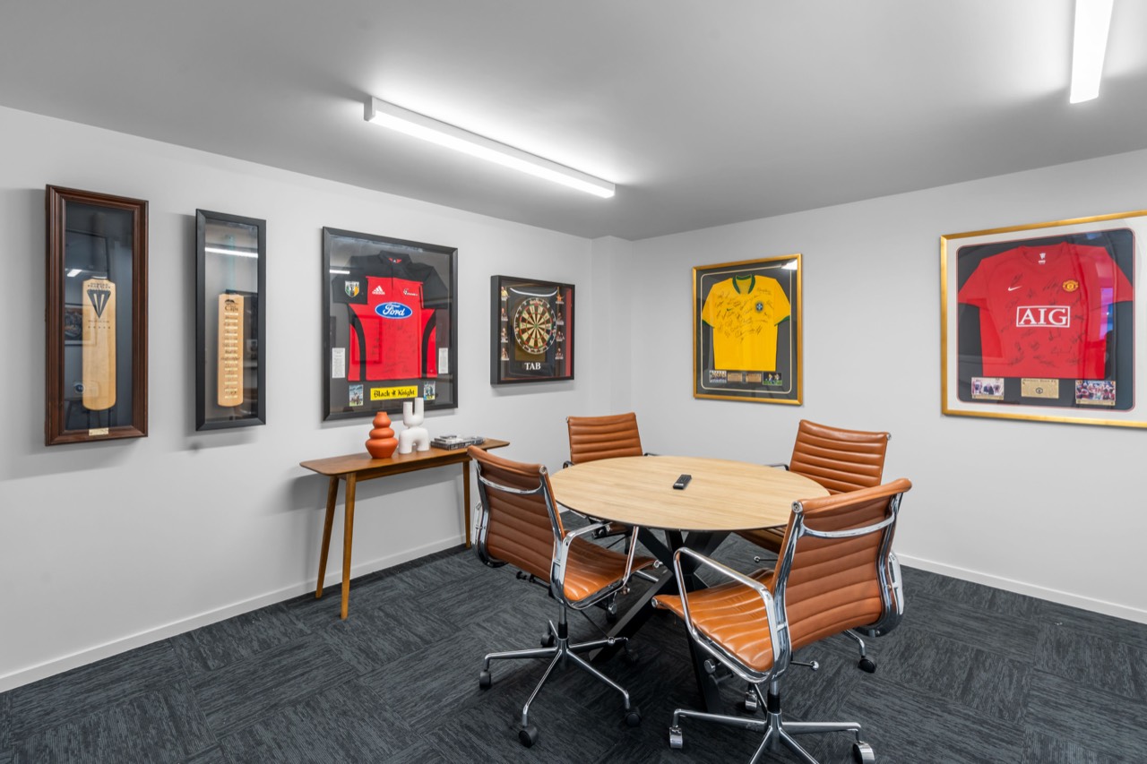 The Sports Room: A round table for four under framed jerseys, with a screen on the wall. Good for client meetings and one-to-ones.