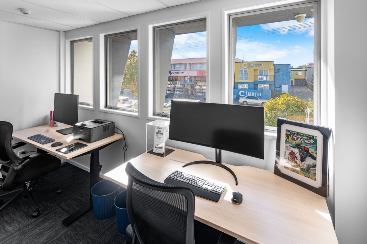 A corner studio with two desks by the windows