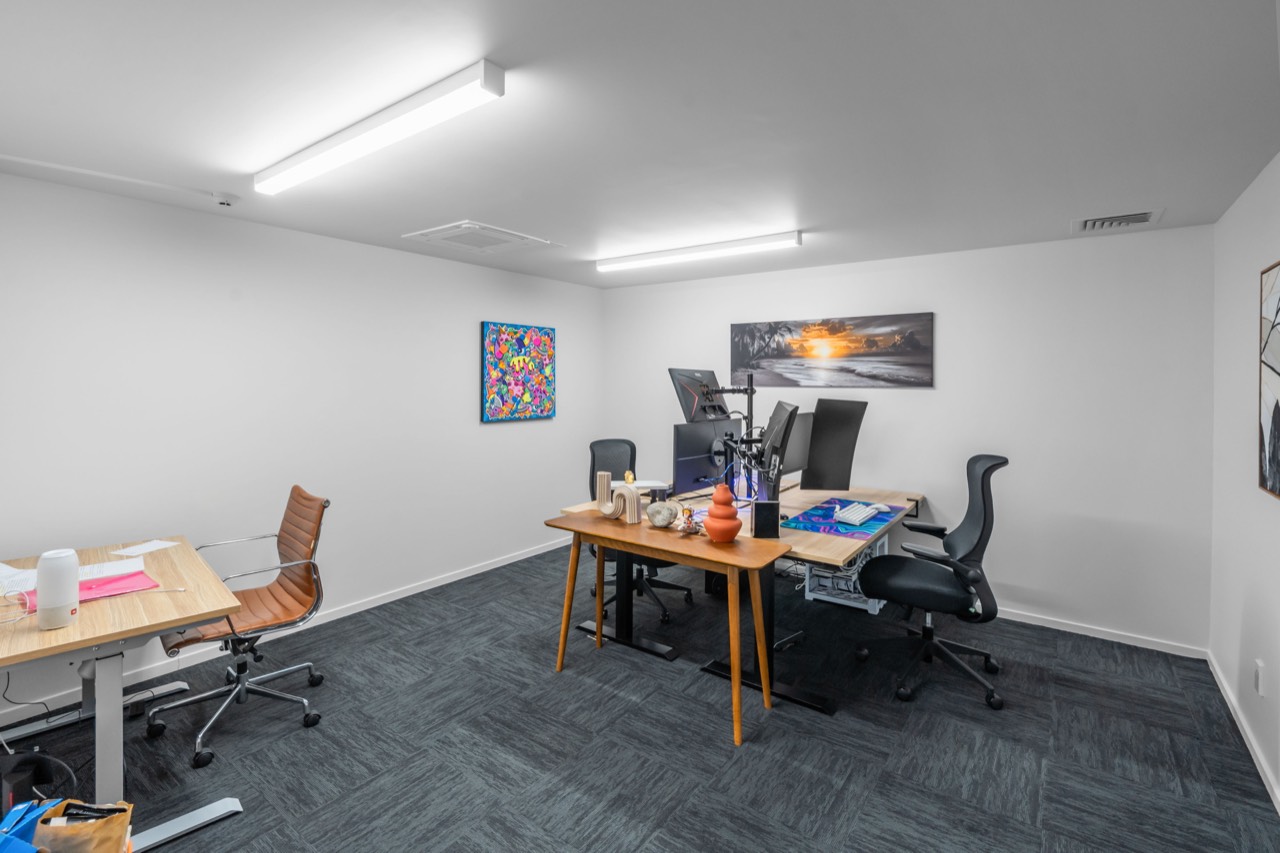 A studio with two desks and artwork